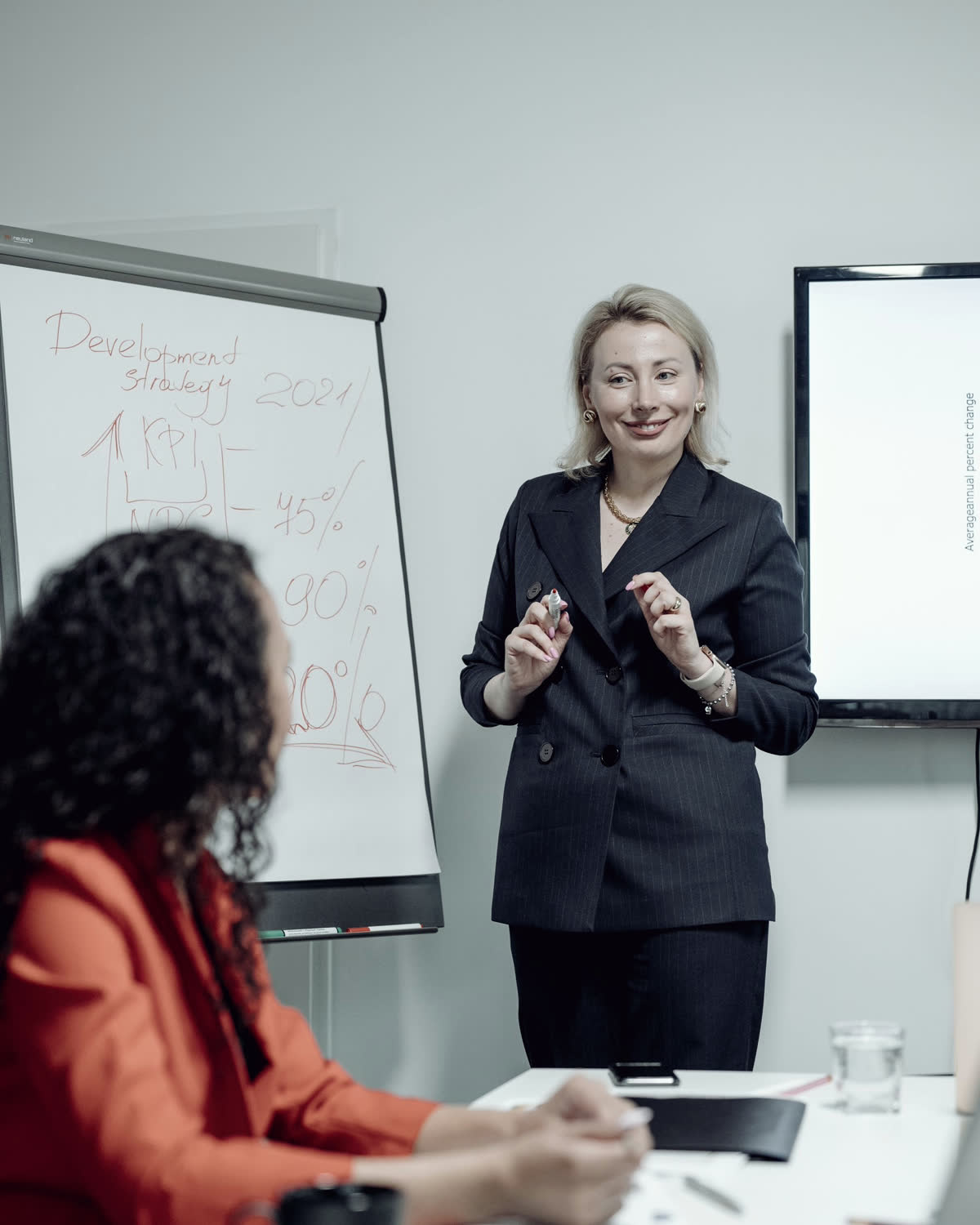 En gründer forklarer ved en tavle mens en kollega lytter